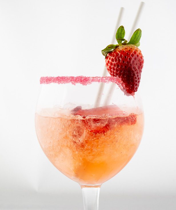 Partial view of a well presented drink with the glass decorated with a strawberry